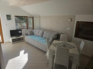 a living room with a couch and a table at Apartmani Gracijela in Karlobag