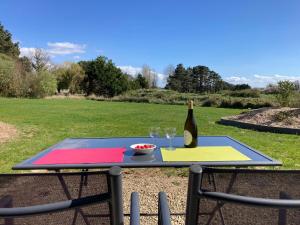 a picnic table with a bottle of wine and glasses at Superbe T2 "Les Enclos" - Vue panoramique, jardin à 5 mn des plages in La Bernerie-en-Retz +34 photos