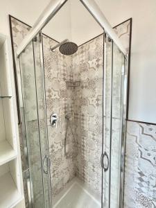 a shower with a glass door and a shower head at Il Mare in Tasca - Casa Vacanze - loc.Torre Lapillo (LE) - Salento in Torre Lapillo