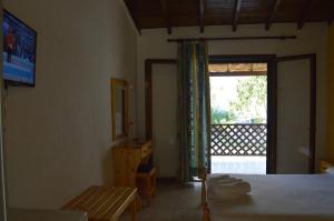 a bedroom with a bed and a sliding glass door at Hotel Zachos in Troulos