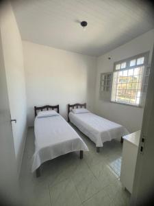 a bedroom with two beds and a window at Casa do açude in Triunfo