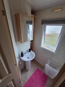 Saint OsythにあるSt Osyth, Clacton-on-sea, Cozy Beach side Caravan, Wifi, Tea and Coffee, Parking includedの小さなバスルーム(シンク、窓付)