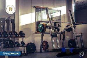 a gym with a bunch of weights on a wall at Bakuriani Raimondo rezidence in Kokotauri