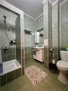 Un baño con ducha, inodoro y lavabo. en Dostyq Haus, en Astana 5 fotos más