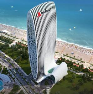 an aerial view of a tall building with a beach at Marriot by Batumi in Batumi