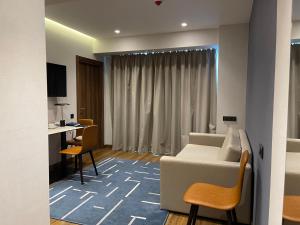 a living room with a white couch and a desk at Marriot by Batumi in Batumi