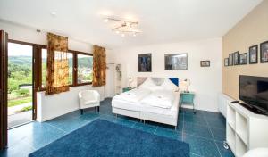 a bedroom with a white bed and a tv at Hinter den Spiegeln in Heimbach