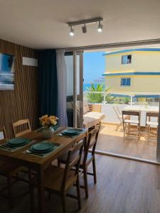 a dining room with a table with chairs and a view of the ocean at BEACH Arguineguin SEA VIEW 6 CHG FAMILY HOTEL in Arguineguín