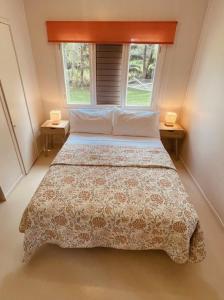 ein Schlafzimmer mit einem Bett mit zwei Lampen auf zwei Tischen in der Unterkunft Mango Grove Cottage in Rarotonga