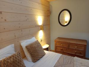 una camera da letto con un letto con una parete in legno di Le Chablis étoilé a Champagnole