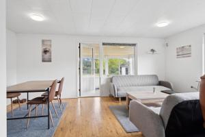 una sala de estar con una mesa y un sofá en The Lucky Peer - 120m2 house 4 bedroom house - full kitchen & free parking, en Odense