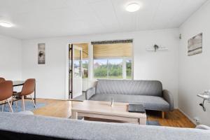 una sala de estar con un sofá y una mesa en The Lucky Peer - 120m2 house 4 bedroom house - full kitchen & free parking, en Odense