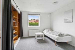Un pequeño dormitorio con una cama y una mesa. en The Lucky Peer - 120m2 house 4 bedroom house - full kitchen & free parking, en Odense