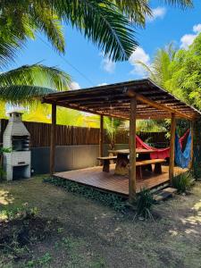 a wooden gazebo with a picnic table and a hammock at Suíte 3 Privativa Taipu de Fora in Barra Grande