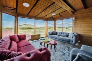 ein Wohnzimmer mit einer Couch und Stühlen und einem Tisch in der Unterkunft Large luxury Cabin On The Golden Circle Next To Kerið The Crater. in Selfoss