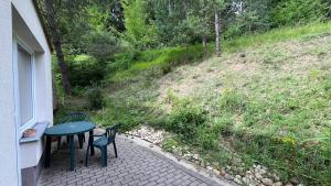 a patio with a table and chairs and a hill at Všemina apartmán s terasou in Všemina