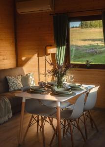 a dining room table with chairs and a couch at Domki Sudecka Przystań in Duszniki Zdrój +24 photos