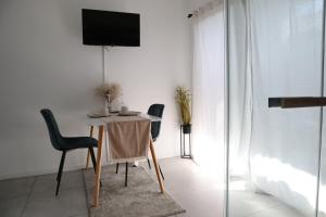 Un comedor con mesa y sillas y un televisor. en RheinMosel Wellness 11, en Coblenza