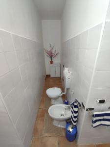 a bathroom with two toilets and a sink at Appartamento vicino alla madonnina di tortona in Tortona