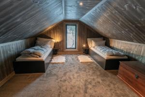 a attic room with two beds and a window at Luxury holiday home, skiing, sauna, remote office in Nystølen