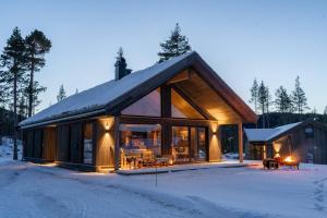 a log cabin in the snow in the winter at Luxury holiday home, skiing, sauna, remote office in Nystølen