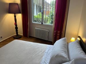 ビセンテ・ロペスにあるCasa con jardín para familias y grupos en Vicente Lópezの窓のある白いベッドのある寝室