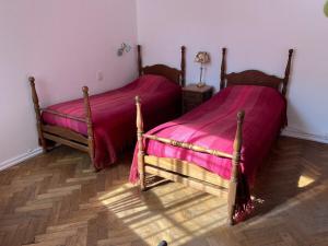 two beds in a bedroom with pink sheets at Villa Selva Mid-century Design House Vicente López in Vicente López