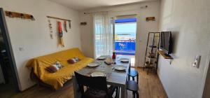 a living room with a couch and a table at Palmier bleu front de mer in Valras-Plage
