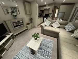 a living room with a couch and a table at Pebble Breeze in Ingoldmells
