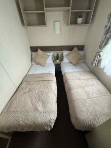 a small room with two beds in it at Pebble Breeze in Ingoldmells