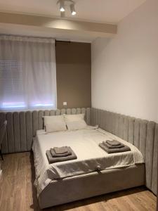 Una cama con dos toallas encima en un dormitorio. en Résidence du centre 8, en Kragujevac