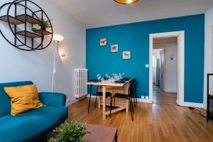 un soggiorno blu con tavolo e parete blu di Appartement 3 chambres Wifi Lorient Centre a Lorient