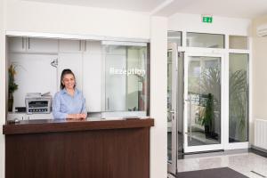 a woman standing at a counter in an office at Hotel Vater Rhein in Wörth am Rhein