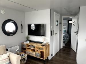 a living room with a television on a wall at Hausboot Hafenprinz Lübeck in Schlutup
