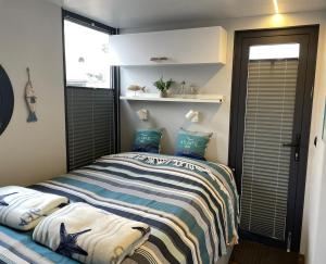 a small bedroom with a bed with blue pillows at Hausboot Hafenprinz Lübeck in Schlutup