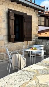a patio with chairs and a table with fruit on it at Levanda House - Traditional House in Vasa Kilaniou