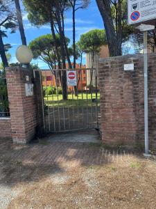 a gate in a brick wall with a do not enter sign at Appartamento calambrone Tirrenia in Tirrenia