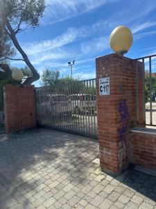 a brick fence with a sign on top of it at Appartamento calambrone Tirrenia in Tirrenia