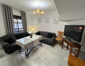 a living room with a couch and a tv at Casa centro casco histórico in Córdoba