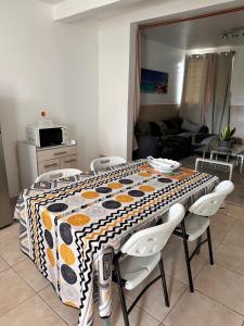 a kitchen with a table with a patterned table cloth at La maison du plateau - Évasion Tropicale in Vieux-Habitants +5 photos