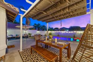 an outdoor patio with a wooden table and chairs at Desert Fun 5BR Retreat with Pool in Bermuda Dunes