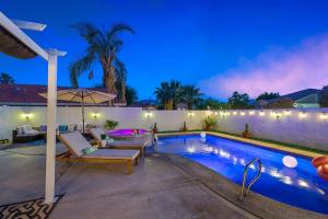 a swimming pool with a patio furniture and an umbrella at Desert Fun 5BR Retreat with Pool in Bermuda Dunes