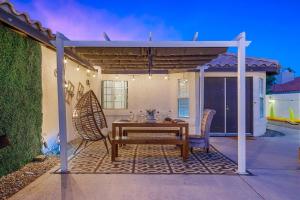 a patio with a table and chairs under a pergola at Desert Fun 5BR Retreat with Pool in Bermuda Dunes +59 photos