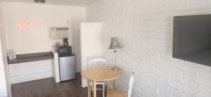 a small kitchen with a small table and a small refrigerator at Brad's Desert Inn in Holbrook