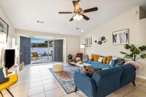 a living room with blue couches and a ceiling fan at 4BR Desert Escape PoolGame Room in Bermuda Dunes +53 photos