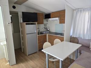 a small kitchen with a white table and a white table at Auto-kamp Dvije suze 2 in Brištane