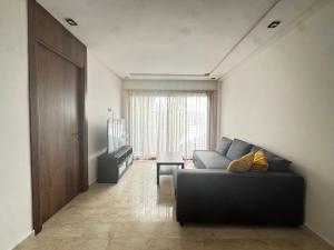 a living room with a couch and a television at Cozy green studio - Self check in, Prime location, Free parking in Casablanca