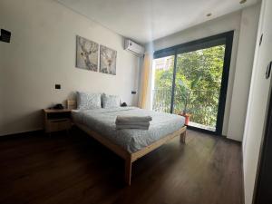 a bedroom with a bed and a large window at Cozy green studio in Casablanca