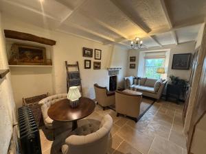 a living room with couches and a table and a fireplace at Arwel Cottage 3 bedroom in Llanbedrog
