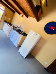 Una cocina con un refrigerador blanco y una encimera. en Hostel Macapa'-KiteAliCori, en Luís Correia